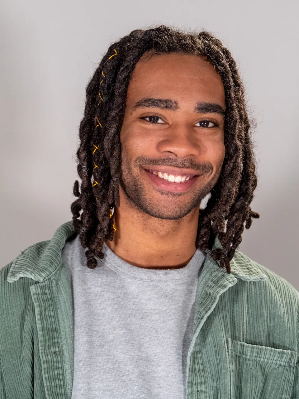 Portrait of Julian Bass smiling in a green overshirt.